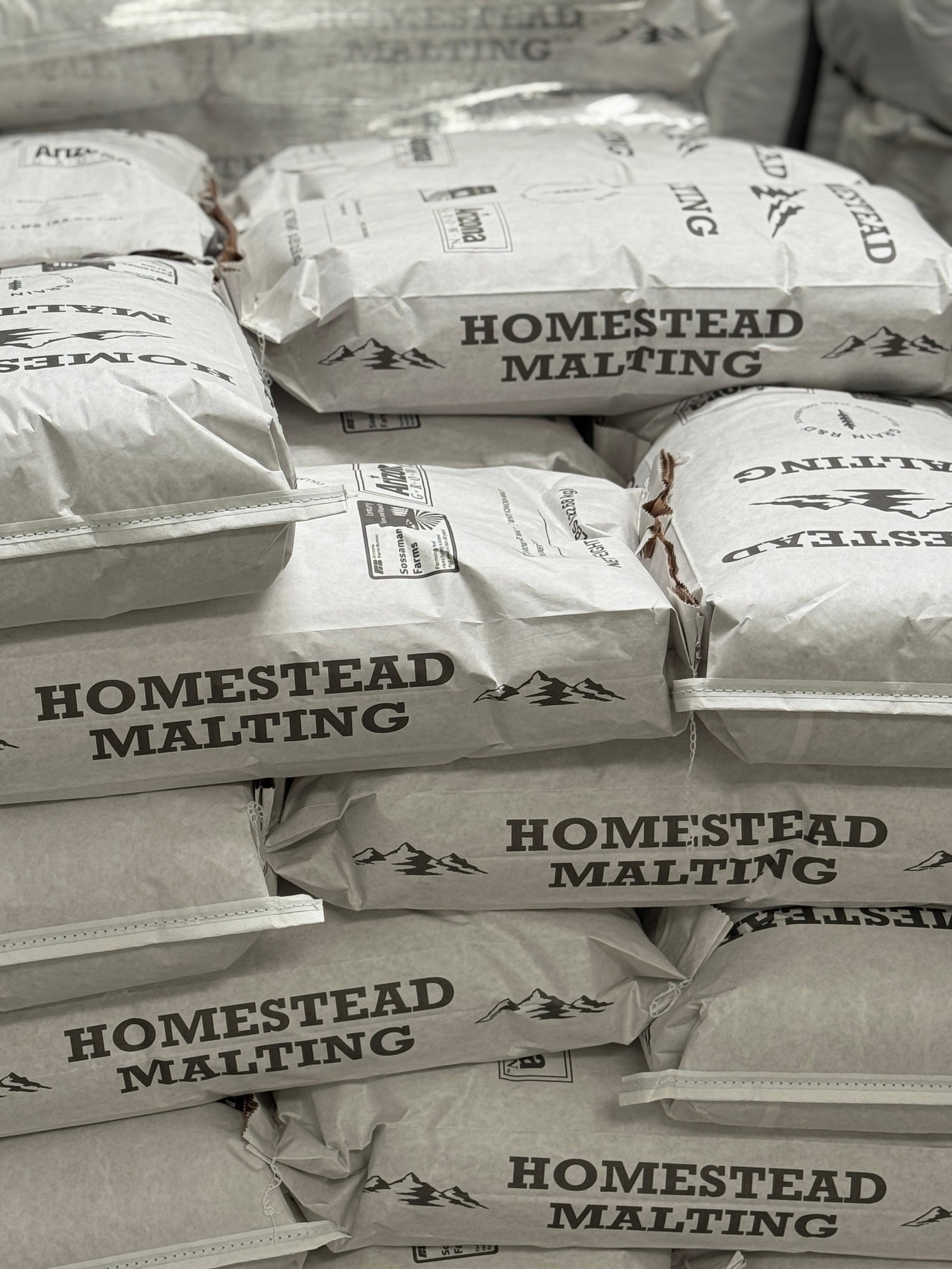 Stacked 50-lb Homestead Malting bags in the Queen Creek malthouse — Arizona Heritage Pale first release malting now
